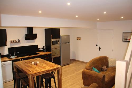 a kitchen and living room with a table and a chair at Appart Côte d'Opale in Condette
