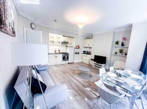 a living room with a couch and a table and chairs at Modern 2-Bed Apartment with Wi-Fi & Parking Near Royal Berkshire Hospital & Reading Station in Reading