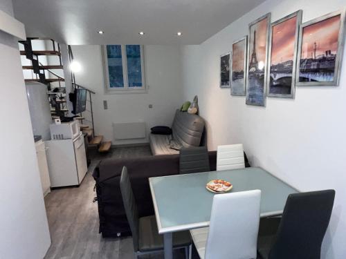 une salle à manger et un salon avec une table et des chaises dans l'établissement Studio mezzanine à proximité du parc Disneyland, à Esbly