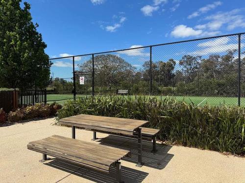 two wooden benches sitting in front of a baseball field at Nagambie Lakes in Nagambie