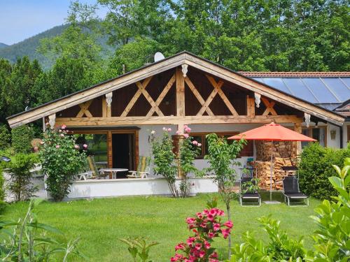 a house with a wooden roof with a patio at Ferienhaus Gottschlicht Bei Rottach Egern Am Tegernsee, Eigener Parkplatz, W Lan in Rottach-Egern