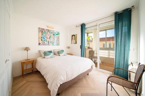 une chambre avec un grand lit blanc et une fenêtre dans l'établissement REF 1960 - Cannes Center - Croisette, à Cannes