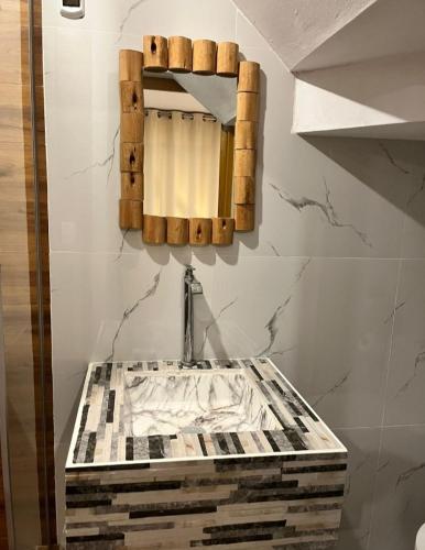 a bathroom with a sink and a mirror on the wall at Hotel Chicama Home and lounge in Puerto Chicama