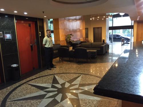 a man standing in the lobby of a building at Tower Icaraí Hotel in Niterói