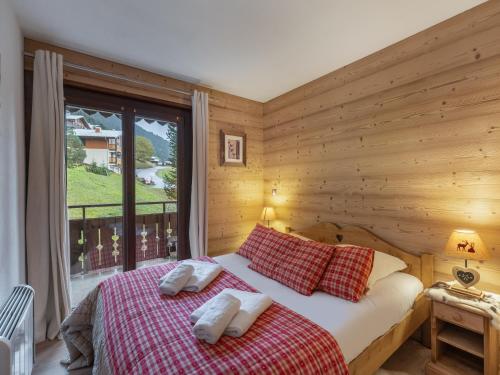 une chambre avec un lit et une grande fenêtre dans l'établissement Le Yeti - Apt B3 N3 - BO Immobilier - Châtel- Châtel Multipass 2025 Été offert par votre hôte, à Châtel