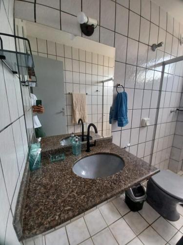 a bathroom with a sink and a toilet at Novidade na Enseada Azul! Apto com churrasqueira, área gourmet e Ar condicionado a 150m da praia in Guarapari