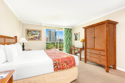 a bedroom with a large bed and a window at Luana Waikiki Hotel & Suites in Honolulu