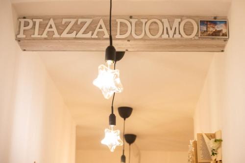 a chandelier hanging from a sign that reads palma dunedin at Luz de Salento B&B in Lecce