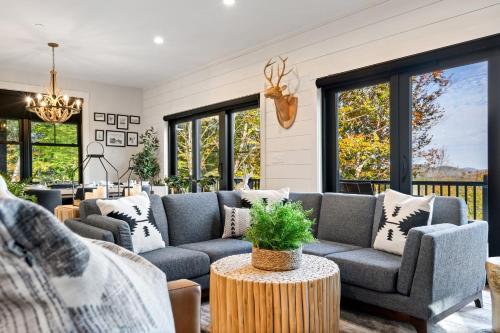 a living room with a couch and a table at Brand New Retreat near Ski Resort, Game Room, Sauna, Hot Tub, Pool in Bethel