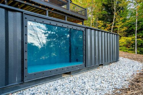 a building with a large window on the side of it at Brand New Retreat near Ski Resort, Game Room, Sauna, Hot Tub, Pool in Bethel