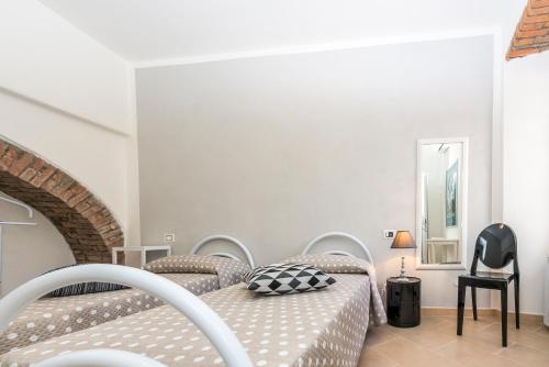 a white bedroom with two beds and a chair at Luxury Apartments Manarola by Arbaspàa in Manarola
