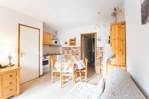 une cuisine et une salle à manger avec une table et un lit dans l'établissement La Joue du Loup, appartement pour 4 avec terrasse, à Saint-Étienne-en-Dévoluy