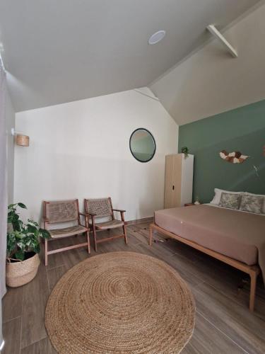 a bedroom with a bed and two chairs and a rug at Favinha Rooftop in Machico