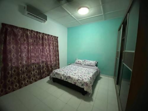 a bedroom with a bed in a room with blue walls at Ayahsu Homestay Ampang in Ampang