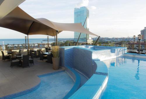 uma piscina com vista para o oceano num edifício em Hotel Bahía Suites na Cidade do Panamá