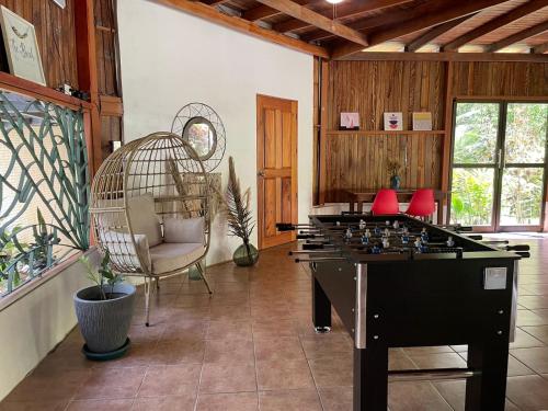 une chambre avec une grande table de jeu et une cage pour oiseaux dans l'établissement La Amapola Lodge, Bungalow en Península de Osa., à Barrigones