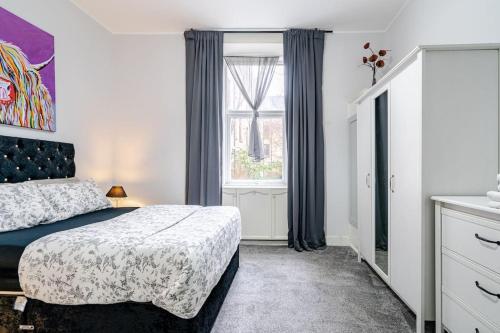a bedroom with a bed and a window at Stunning Ground Floor flat in Southside. in Glasgow