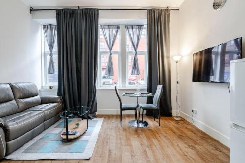 a living room with a couch and a table at Stunning Ground Floor flat in Southside. in Glasgow