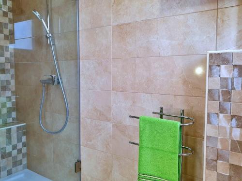 a shower with a green towel in a bathroom at Villa Rebeka in Šilo