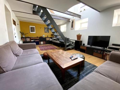 un salon avec un canapé et une table basse dans l'établissement Un jardin en ville, à Strasbourg