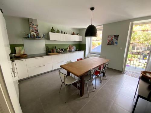 une cuisine avec une table et des chaises en bois dans l'établissement Un jardin en ville, à Strasbourg