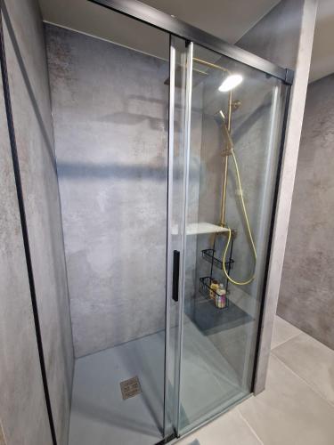 a shower with a glass door in a room at Favinha Rooftop in Machico