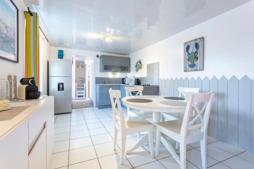 une cuisine et une salle à manger avec une table et des chaises dans l'établissement Maison de pêcheur 300m de la mer, à Penmarcʼh