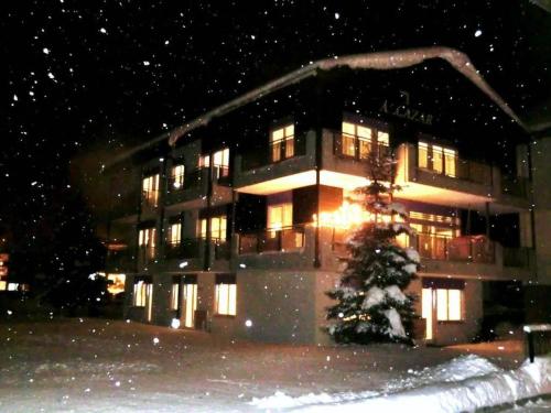 a building with a christmas tree in front of it at Apartment Alcazar by Interhome in Saas-Grund