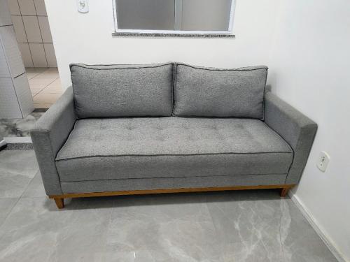 a grey couch sitting in a room next to a wall at renascer in Mauá