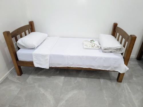 a bed with white sheets and pillows on it at renascer in Mauá