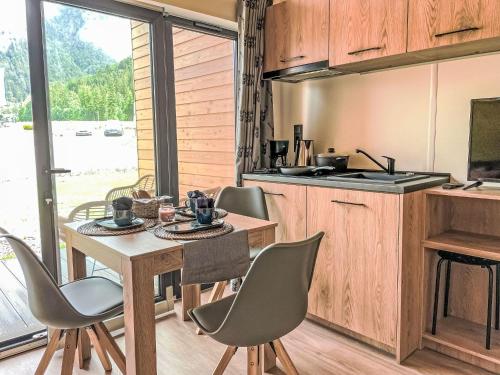 a kitchen with a table and chairs and a kitchen with a window at Holiday Home Tiny Haus Glockenalm-Haus 4-Jahreszeiten by Interhome in Aurach