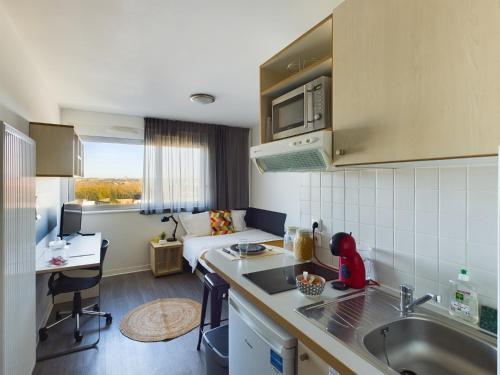 une cuisine avec un évier et un salon dans l'établissement Résidence Kley Toulouse, à Toulouse