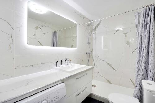 une salle de bain blanche avec un lavabo et un miroir dans l'établissement Confort et Charme pour 6 à Republioque, à Paris
