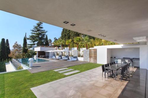 un patio extérieur avec une table et des chaises ainsi qu'une arrière-cour dans l'établissement REF 1960 - Cannes - Sea view villa for rent, à Cannes