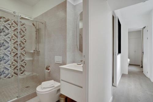 une salle de bain blanche avec toilettes et douche dans l'établissement Sublime Paris apartment 3Br-10P, à Paris