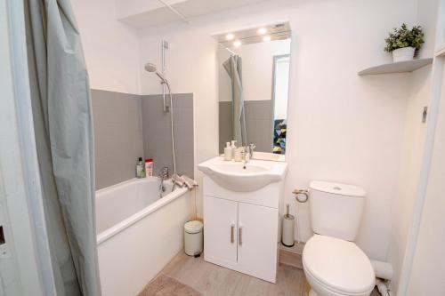 a bathroom with a toilet and a sink and a bath tub at Escapade Au Calme De La Rivière in Métabief