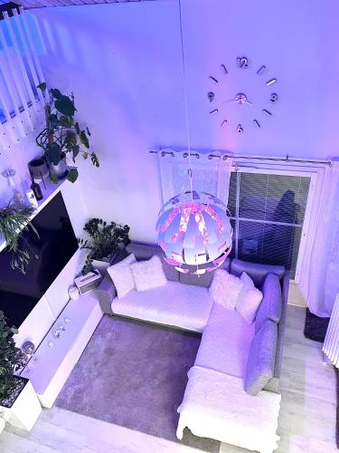a living room with a purple couch and a clock at Hopea Villa in Vuokatti