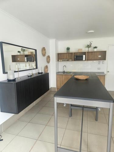 a kitchen with a black table and a mirror at Cómodo departamento sector norte arriendo por dia Edificio Velas del norte 1 in Antofagasta