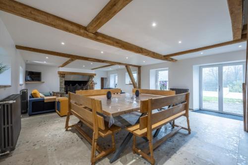 a kitchen and living room with a wooden table at Gîte de luxe avec piscine privée 14 pers Clécy in Clécy