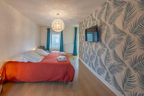 a bedroom with a red bed and a wall at Gîte de luxe avec piscine privée 14 pers Clécy in Clécy