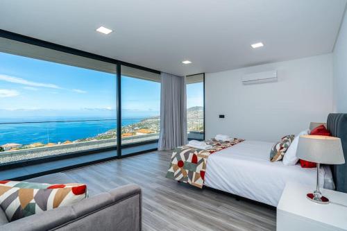 a bedroom with a bed and a view of the ocean at Villa Lunarenzo seaview, Pool, AC, parking in Calheta