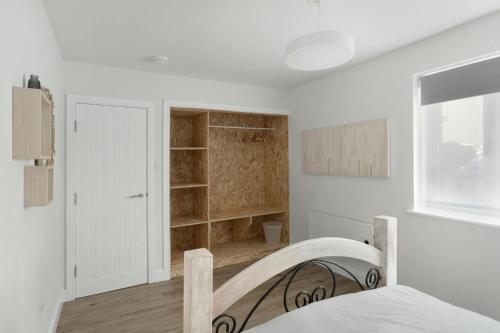 a white bedroom with a bed and a closet at Mulberry in Bowness-on-Windermere