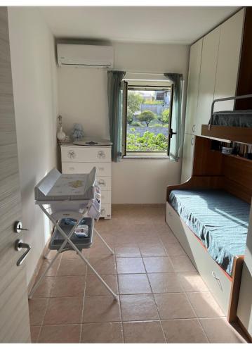 a room with a bed and a table and a window at Villetta da sogno fronte mare in Bianco