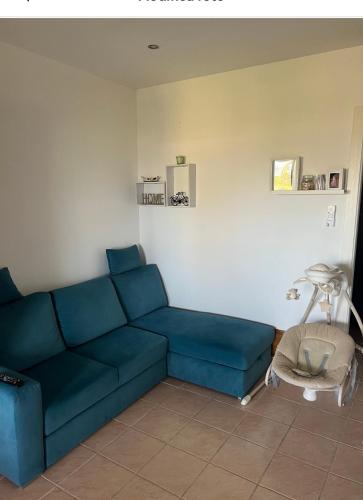 a living room with a blue couch and a table at Villetta da sogno fronte mare in Bianco