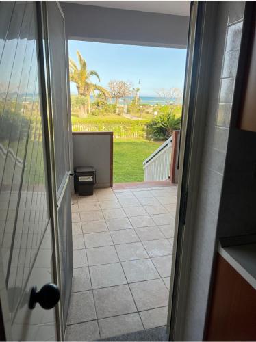 an open door to a patio with a view of the ocean at Villetta da sogno fronte mare in Bianco