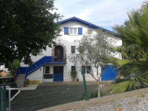 uma casa branca com um telhado azul em Appartement Bigarena em Hendaye