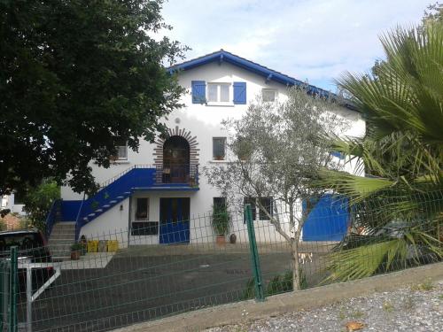 une maison blanche avec un toit bleu dans l'établissement Appartement Bigarena, à Hendaye