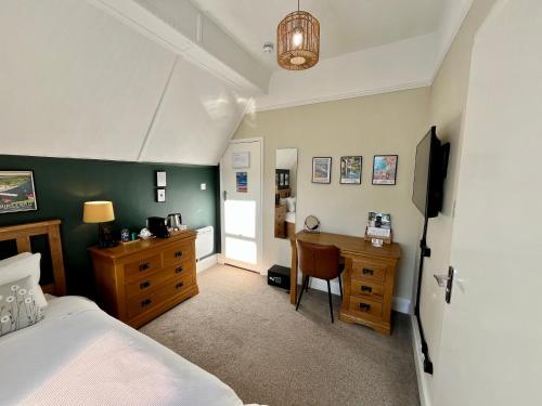 a bedroom with a bed and a desk and a table at The Devonian in Ilfracombe