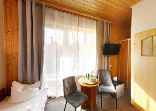 a bedroom with a window with a table and chairs at Dom Wypoczynkowy Topaz in Szklarska Poręba