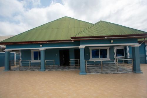 a blue building with a green roof at Yaa Asantewaa Inn in Ejisu